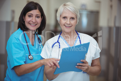 Portrait of female surgeon and nurse having discussion on file