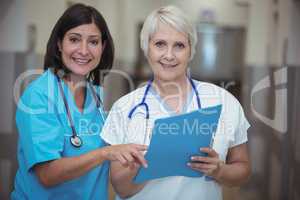 Portrait of female surgeon and nurse having discussion on file
