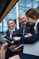 Businesspeople discussing over laptop and digital tablet