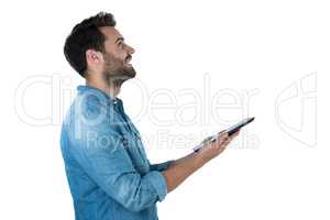 Handsome man looking up while holding a digital tablet