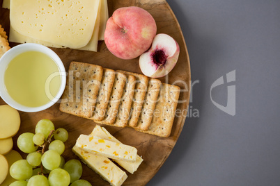 Variety of cheese with grapes, peach and crackers