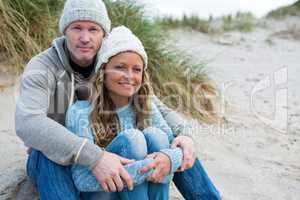 Happy couple sitting on shore