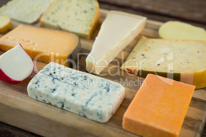 Variety of cheese on wooden board