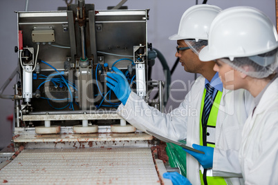 Technicians examining meat processing machine