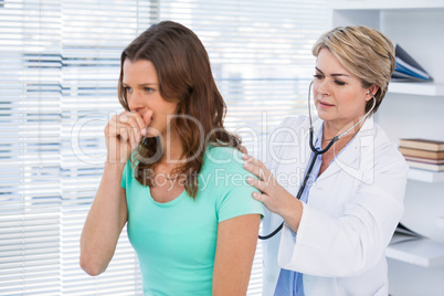 Doctor examining coughing patient with stethoscope