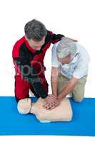 Paramedic training cardiopulmonary resuscitation to senior man
