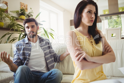 Upset couple arguing with each other on sofa