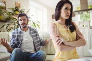 Upset couple arguing with each other on sofa