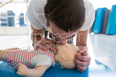 Paramedic practising resuscitation mouth to mouth on dummy