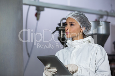 Female butcher using digital tablet