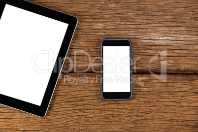 Digital tablet and smartphone on wooden plank