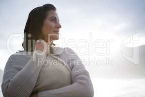 Thoughtful woman in sweater on beach