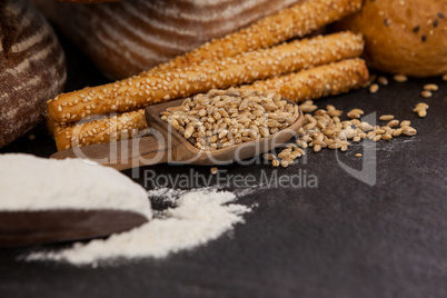 Various bread loaves with flour and wheat grains