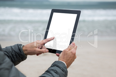 Man using digital tablet on beach