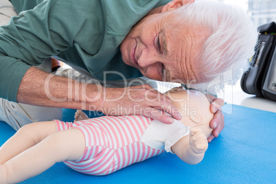 Paramedic practicing resuscitation on dummy