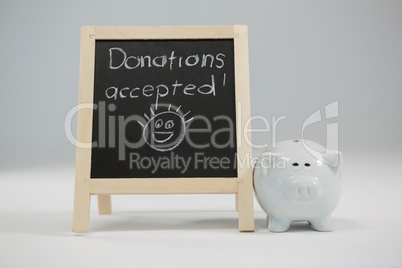 Donation accepted written on slate with piggy bank