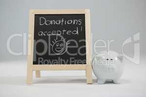 Donation accepted written on slate with piggy bank