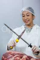 Female butcher sharpening her knife