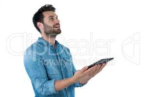 Handsome man looking up while holding a digital tablet