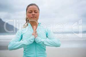 Woman performing yoga on beach