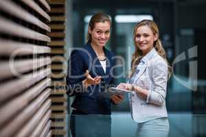 Business colleagues using digital tablet in office lobby