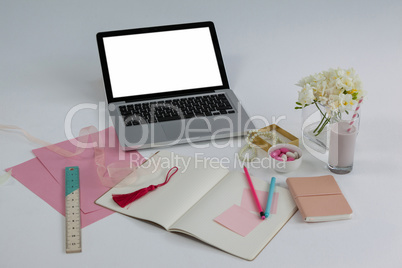 Laptop, diary, ruler, pages, sticky notes, flowers and pencil