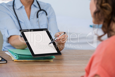 Doctor discussing with patient over digital tablet at the hospital