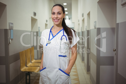 Portrait of female nurse standing in corridor