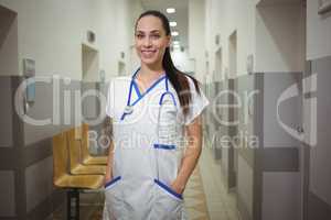 Portrait of female nurse standing in corridor