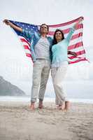 Couple holding american flag on beach