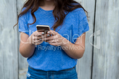 Woman in blue top using mobile phone