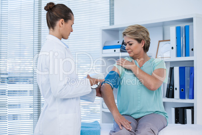 Female doctor checking blood pressure of a patient