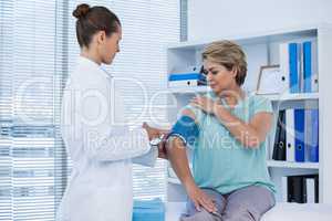 Female doctor checking blood pressure of a patient