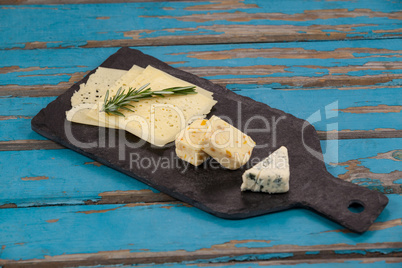 Cheese with rosemary on chopping board