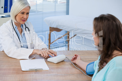 Female doctor checking blood pressure of a patient