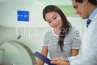 Doctor and patient discussing over clipboard