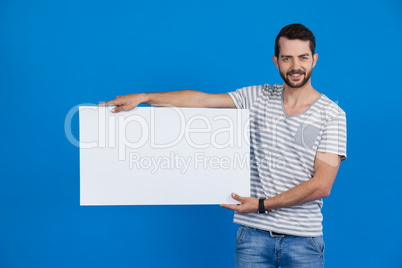 Handsome man holding a blank placard