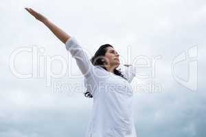 Happy woman standing with arms outstretched