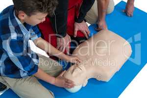 Paramedic training cardiopulmonary resuscitation to boy