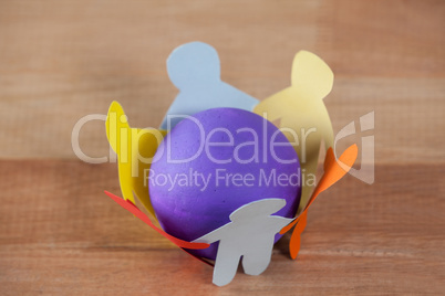 Multicolored paper cut outs forming a circle with a ball in between