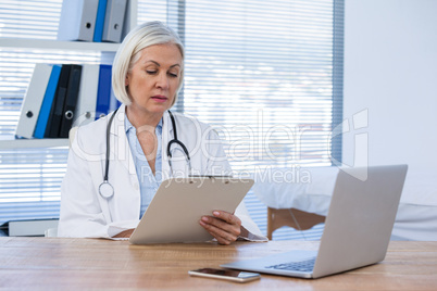 Female doctor looking at clipboard