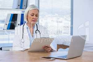 Female doctor looking at clipboard