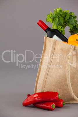 Wine bottle and vegetables in grocery bag