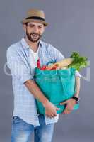 Man in fedora hat carrying groceries bag