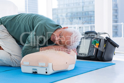 Paramedic practicing resuscitation on dummy