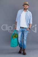 Man in fedora hat holding grocery bag