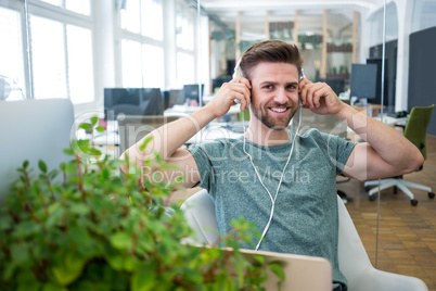 Portrait of graphic designer listening to music on head phone