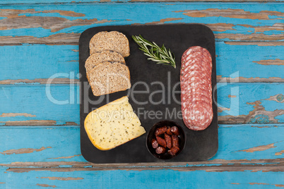 Brown bread, dutch gouda cheese, rosemary and ham on slate board