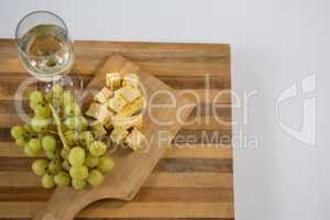 Cubes of cheese with grapes and wine glass