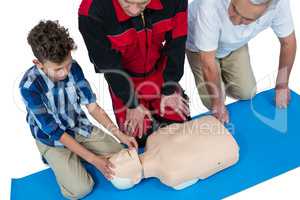 Paramedic training cardiopulmonary resuscitation to senior man and boy